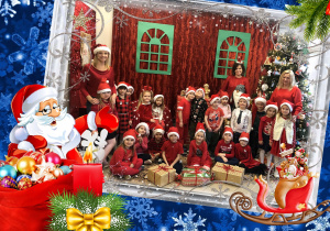 Dzieci z Jeżyków ubrane na czerwono z panią Olą i z panią Agnieszką na tle dekoracji przedstawiającej domek Mikołaja